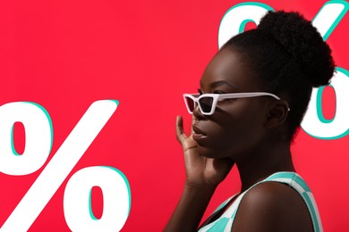 Image of Woman in stylish sunglasses and percent signs on red background