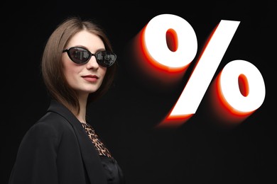 Image of Fashionable woman and percent sign against black background