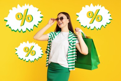 Image of Happy woman with shopping bags and percent signs against yellow background