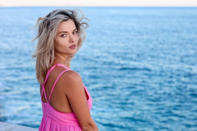 Photo of Beautiful woman near sea on summer day, space for text