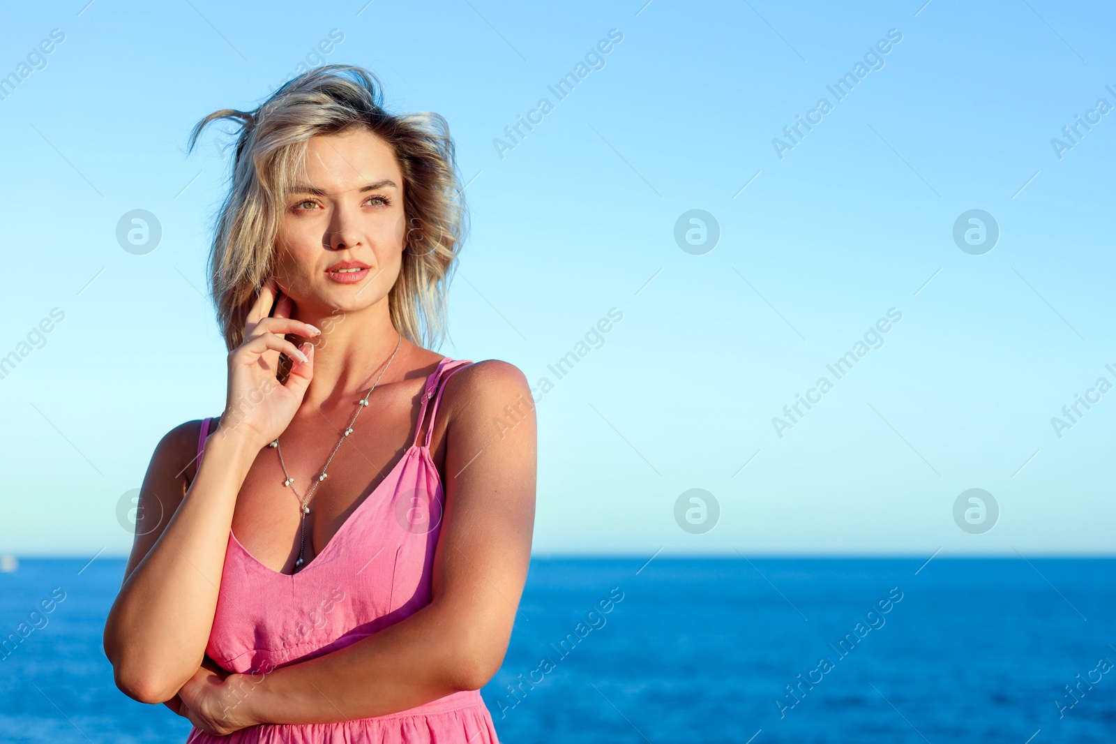 Photo of Beautiful woman near sea on summer day, space for text