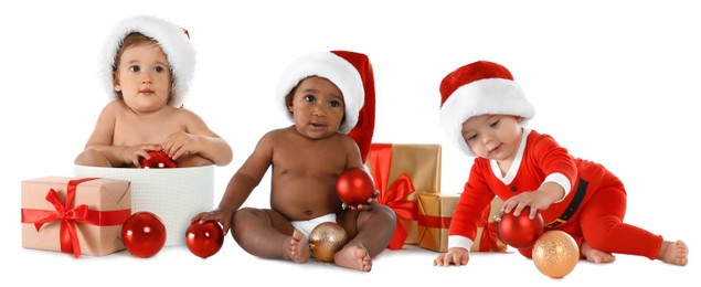 Image of Adorable babies with Santa hats, Christmas balls and gift boxes on white background