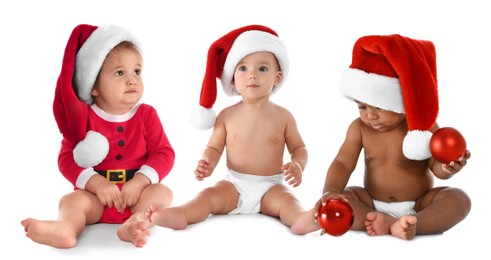 Image of Adorable babies with Santa hats and Christmas balls on white background