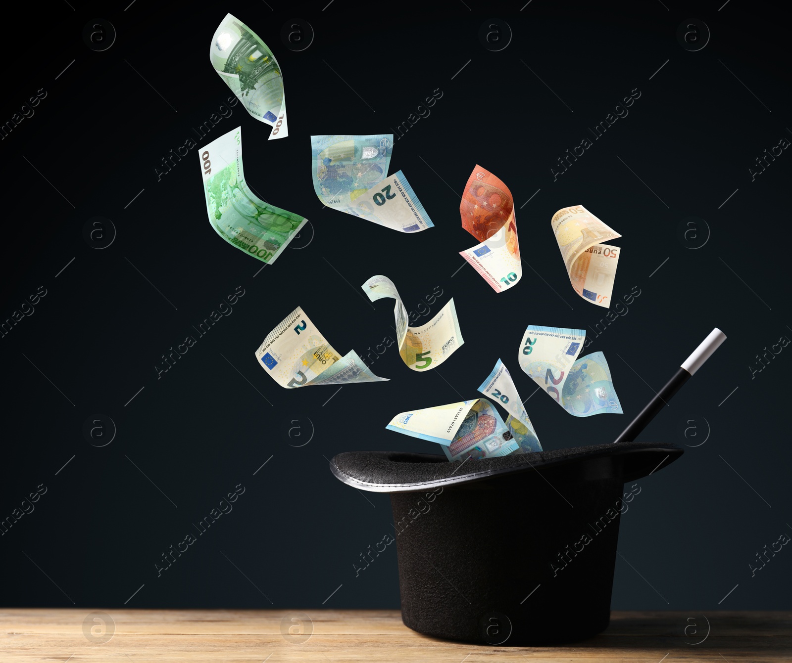 Image of Money flying out of magician's hat against black background