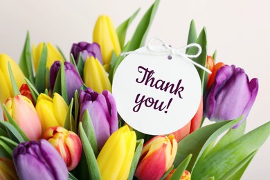 Image of Thank tag and bouquet of tulips against white background