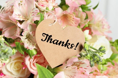 Image of Heart-shaped Thank tag and bouquet of flowers , closeup