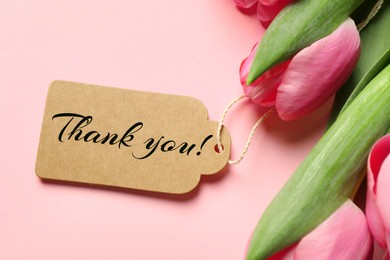 Image of Thank tag and tulip flowers on pink background