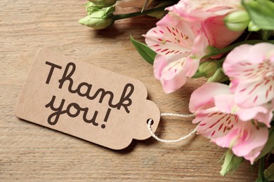 Image of Thank tag and beautiful flowers on wooden table