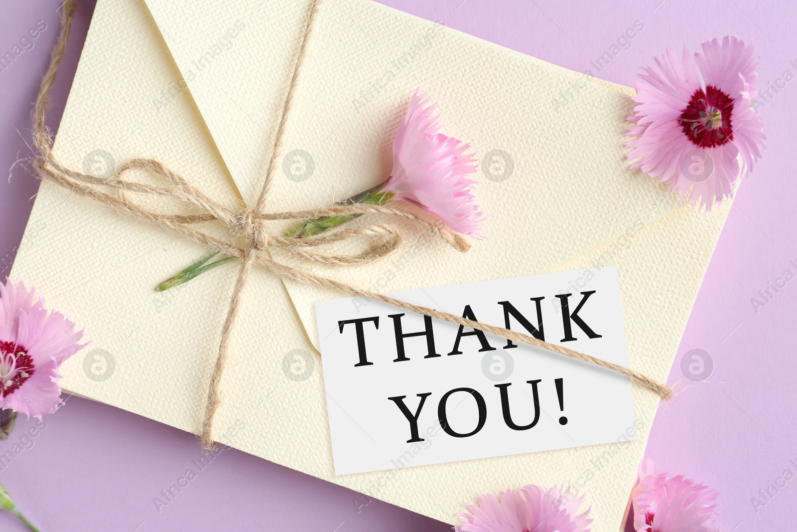Image of Thank tag, flowers and stack of letters on violet background, top view