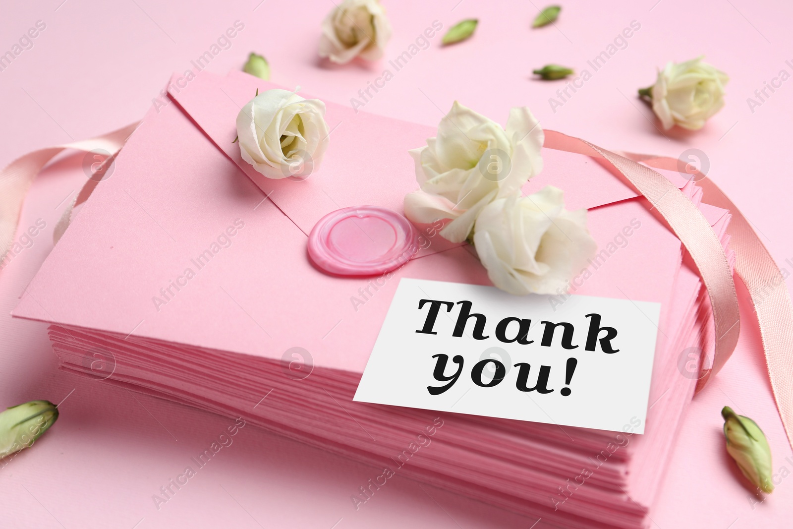 Image of Thank card, flowers and letters on pink background