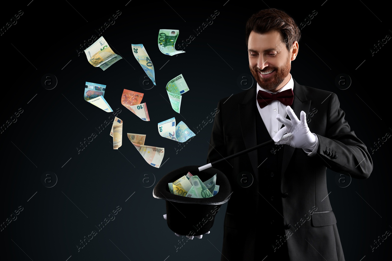 Image of Magician performing trick with money flying out of hat against black background