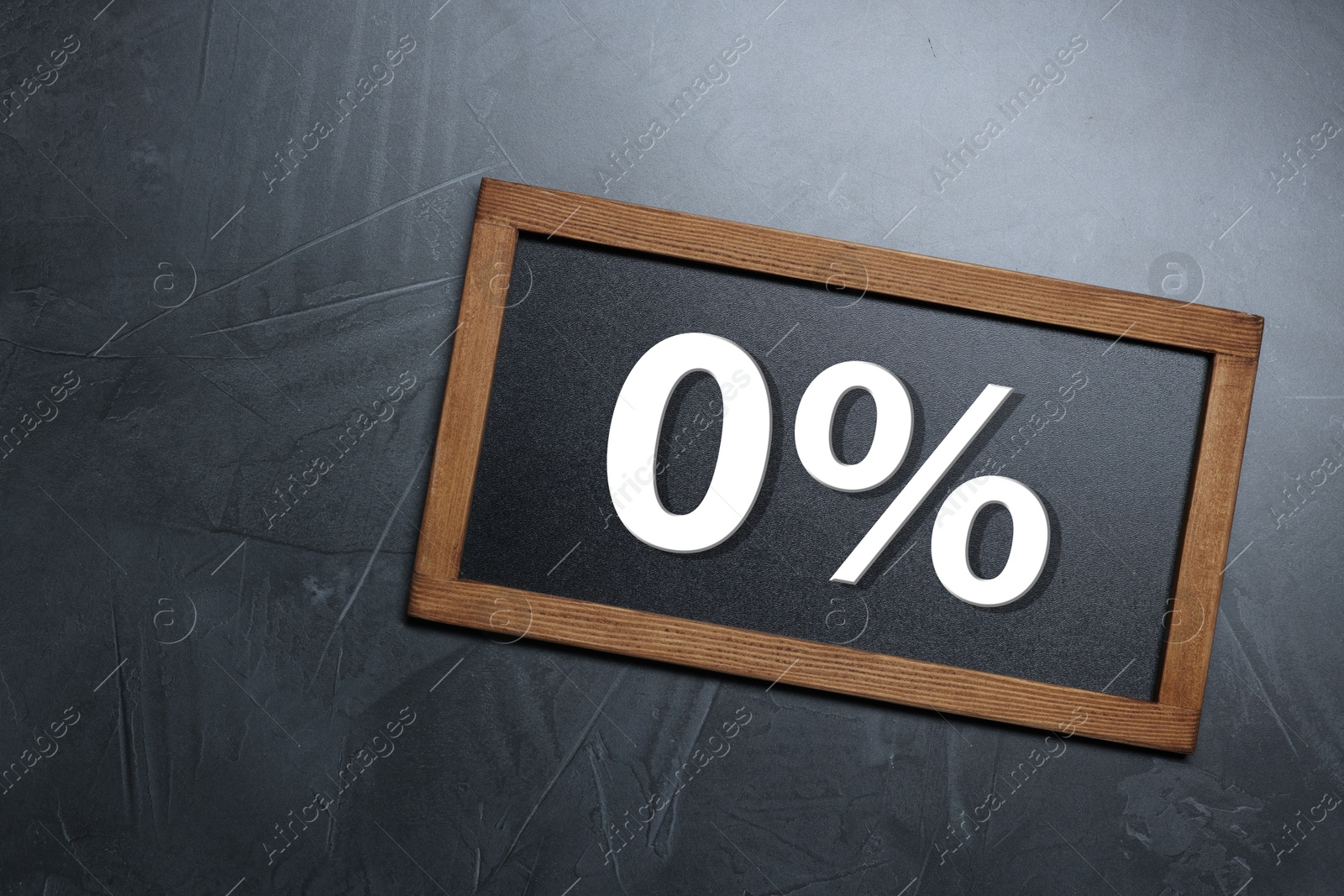 Image of Zero percent commission. Chalkboard with 0% on grey textured background, top view