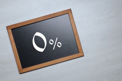Image of Zero percent commission. Chalkboard with 0% on wooden background, top view