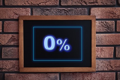 Image of Zero percent commission. Chalkboard with 0% hanging on brick wall