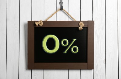 Image of Zero percent commission. Chalkboard with 0% hanging on white wooden wall