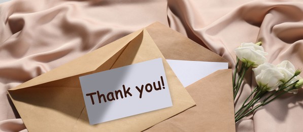 Image of Thank card, envelopes and flowers on beige fabric