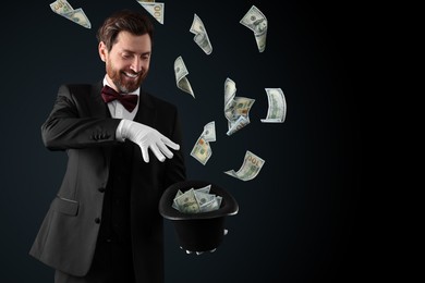 Image of Magician performing trick with money flying out of hat against black background