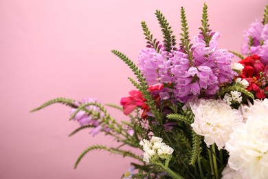 Photo of Many beautiful flowers on pink background, closeup. Space for text