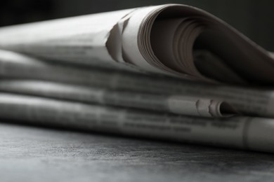 Photo of Stack of newspapers on grey table, closeup
