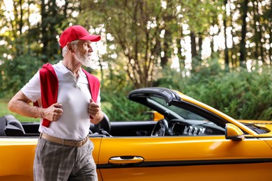 Photo of Stylish senior man near modern cabriolet outdoors