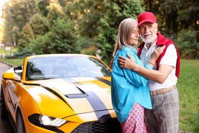 Photo of Stylish senior couple near modern cabriolet outdoors