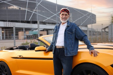 Photo of Stylish senior man near modern cabriolet outdoors