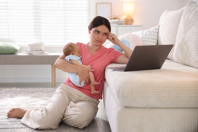 Photo of Telehealth. Mother with her baby leaning on sofa and having online consultation with doctor at home