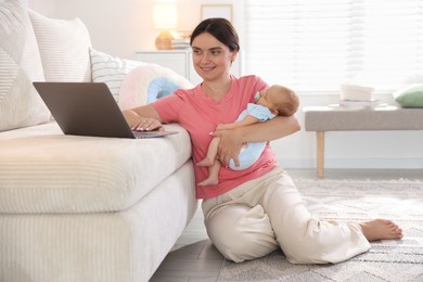 Photo of Telehealth. Smiling mother with her baby leaning on sofa and having online consultation with doctor at home