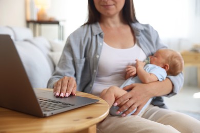 Photo of Telehealth. Mother with her baby having online consultation with doctor at table indoors, closeup