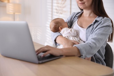 Photo of Telehealth. Mother with her baby having online consultation with doctor at table indoors, closeup