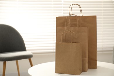 Photo of Paper bags on white table indoors, closeup. Space for text