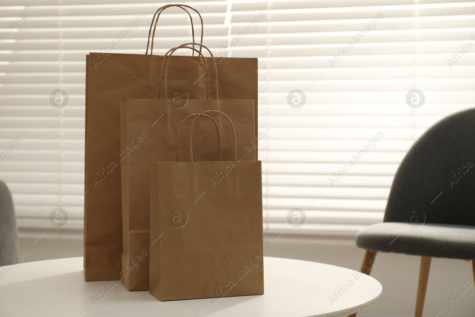 Photo of Paper bags on white table indoors, closeup. Space for text
