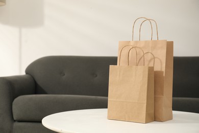 Photo of Paper bags on white table indoors, closeup. Space for text
