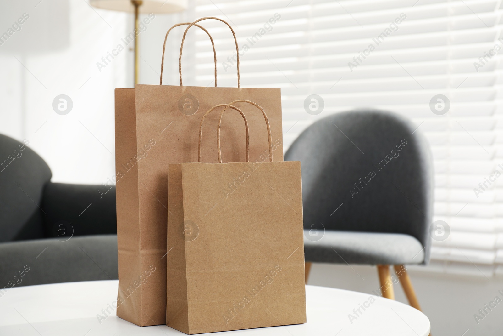 Photo of Paper bags on white table indoors, closeup. Space for text