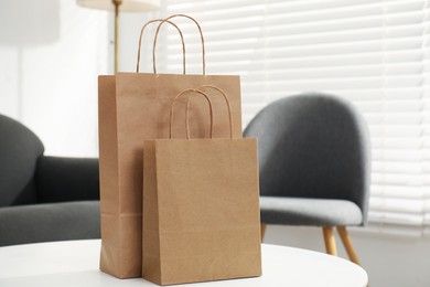 Photo of Paper bags on white table indoors, closeup. Space for text