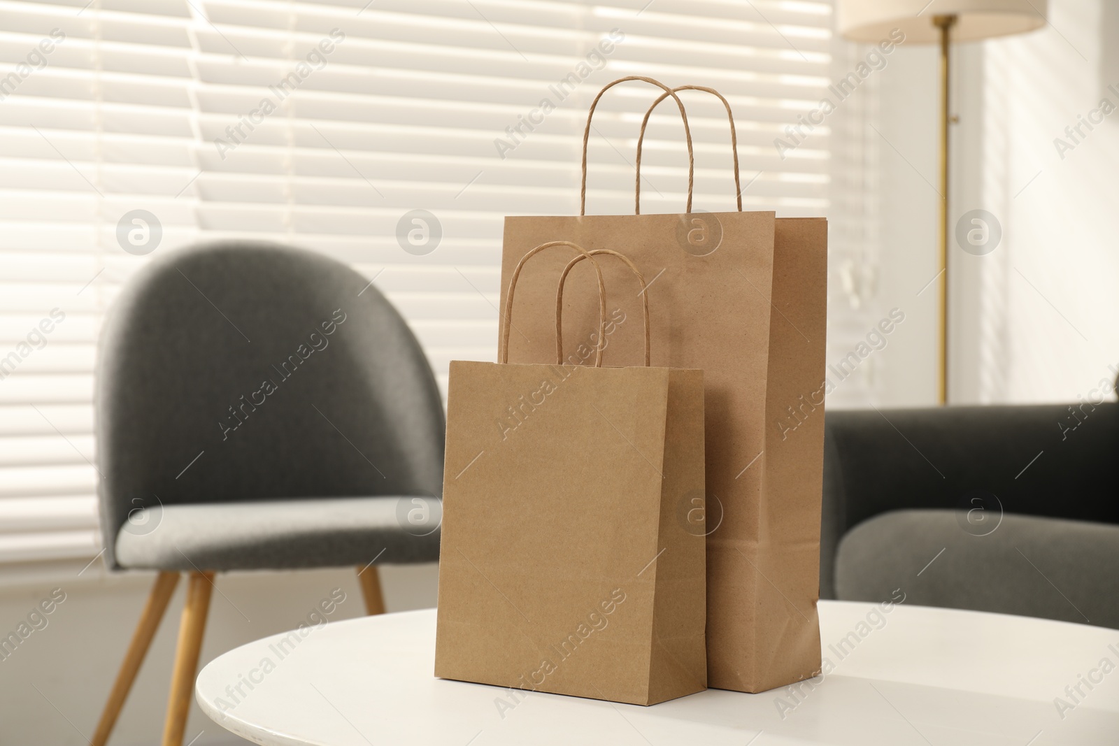 Photo of Paper bags on white table indoors, closeup. Space for text