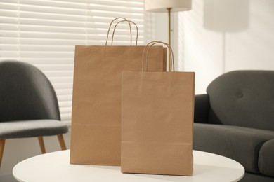 Photo of Paper bags on white table indoors, closeup