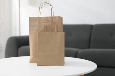Photo of Paper bags on white table indoors. Space for text