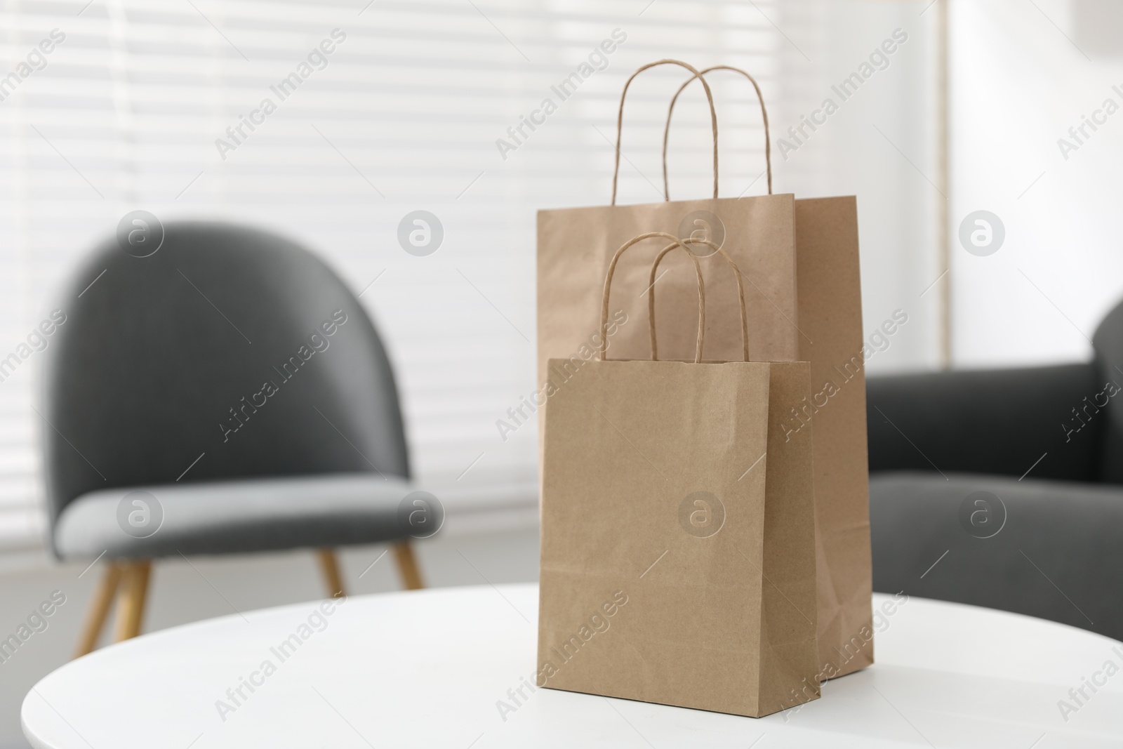 Photo of Paper bags on white table indoors. Space for text