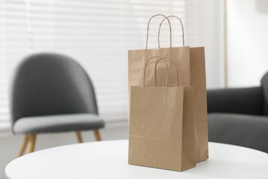 Photo of Paper bags on white table indoors. Space for text