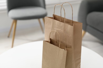 Photo of Paper bags on white table indoors. Space for text