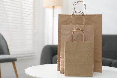 Photo of Paper bags on white table indoors. Space for text