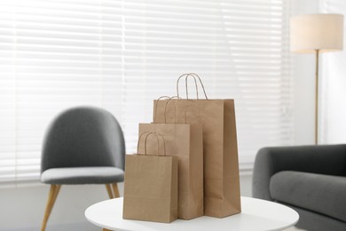 Photo of Paper bags on white table indoors. Space for text