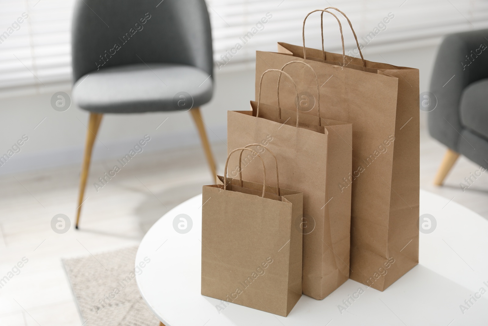 Photo of Paper bags on white table indoors. Space for text