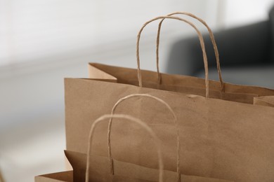 Photo of Paper bags with handles against blurred background, closeup