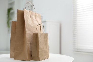 Photo of Paper bags on white table indoors. Space for text