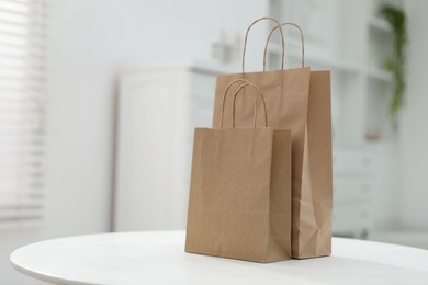 Photo of Paper bags on white table indoors. Space for text