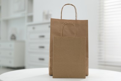 Photo of Paper bags on white table indoors. Space for text
