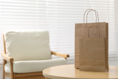 Photo of Paper bags on wooden table indoors, closeup. Space for text