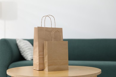 Photo of Paper bags on wooden table indoors, closeup. Space for text